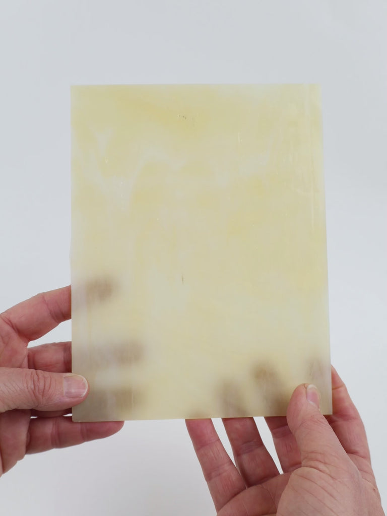 Video of the Clear Ivory glass plate in beige translucent marbled, 15x19cm, held up and tilted to show its pattern and transparency