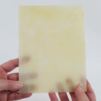 Video of the Clear Ivory glass plate in beige translucent marbled, 15x19cm, held up and tilted to show its pattern and transparency