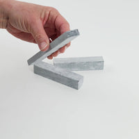 Video of Marble Bars XL Nero Lavica in opaque dark grey natural marble, 1–20 cm long and 8 mm thick, picked up by hand and turned to show their length, colour and natural veining