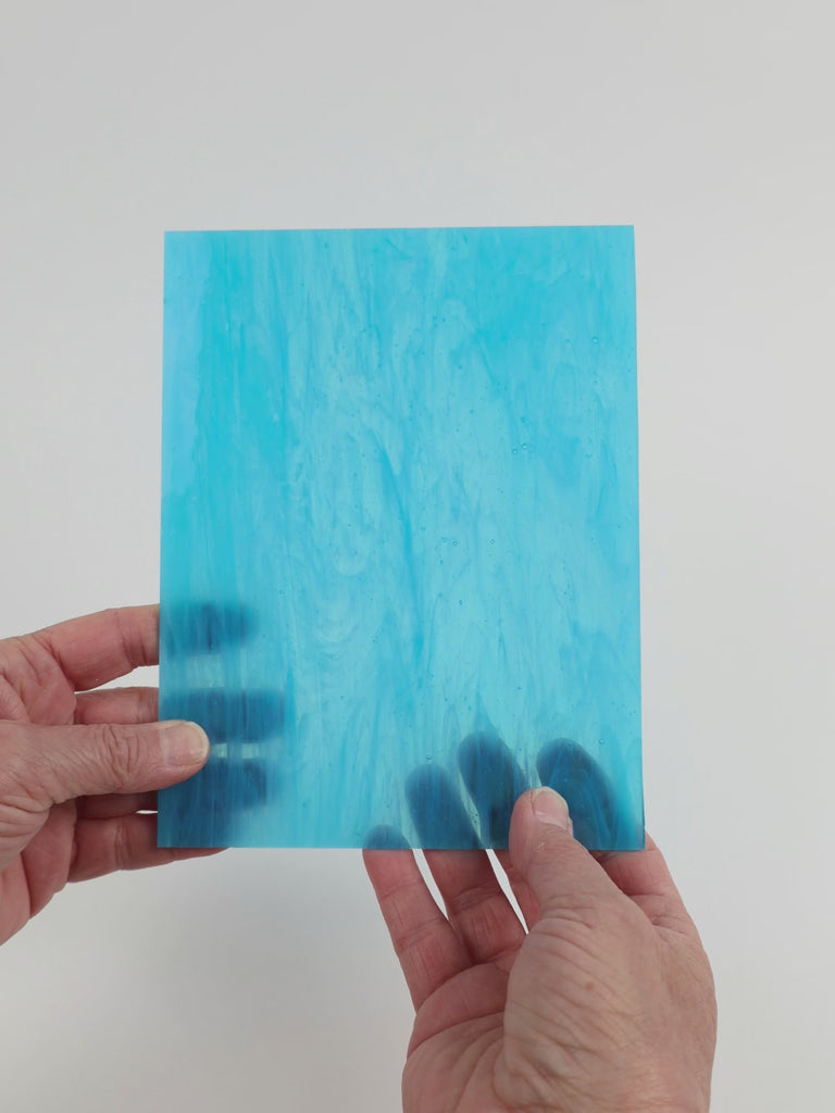 Video of the Egyptian Scarab glass plate in translucent turquoise, 15x19cm, held up and tilted to show its pattern and transparency