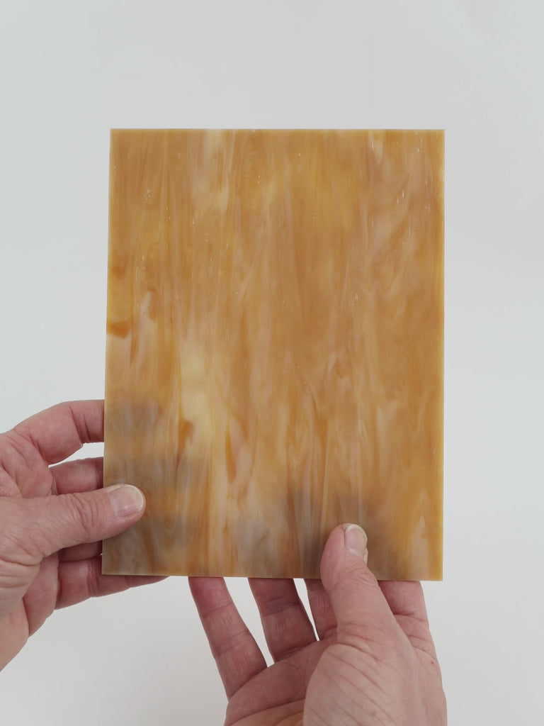 Video of the butterscotch glass plate in brown translucent, 15x19cm, held up and tilted to show its pattern and transparency