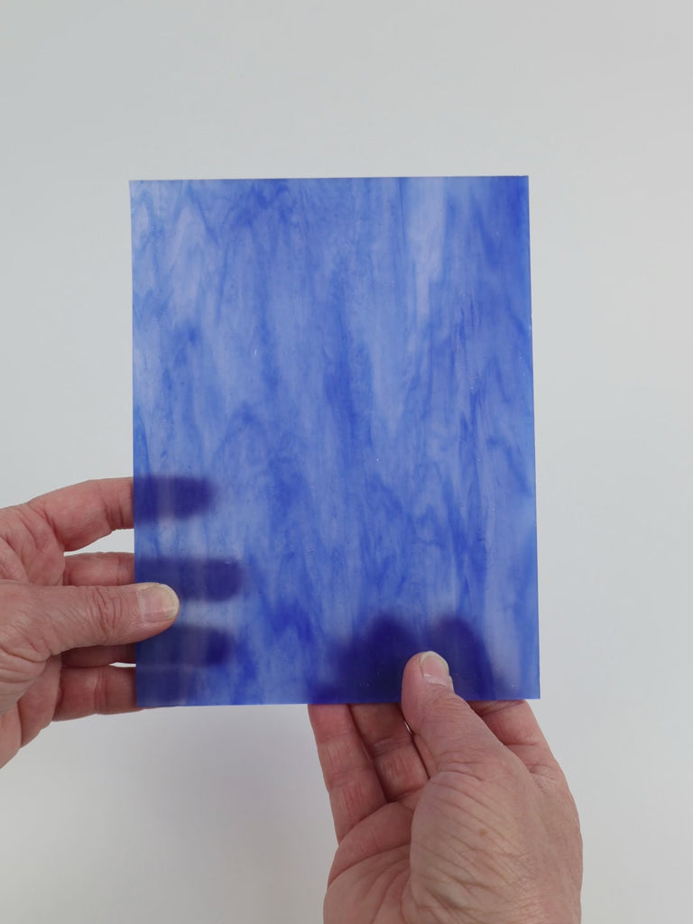 Video of the Blue Wispy glass plate in translucent blue, 15x19cm, held up and tilted to show its pattern and transparency