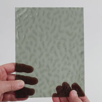 Video of the grey ripple glass plate in grey transparant mottle, 15x19cm, held up and tilted to show its pattern and transparency